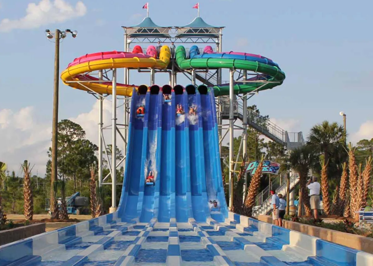 This lively image features colorful water slides, swimmers enjoying the splash area, and palm trees, capturing the spirit of Waterville USA Waterpark. The scene bursts with energy, promising fun-filled family outings close to the condo.